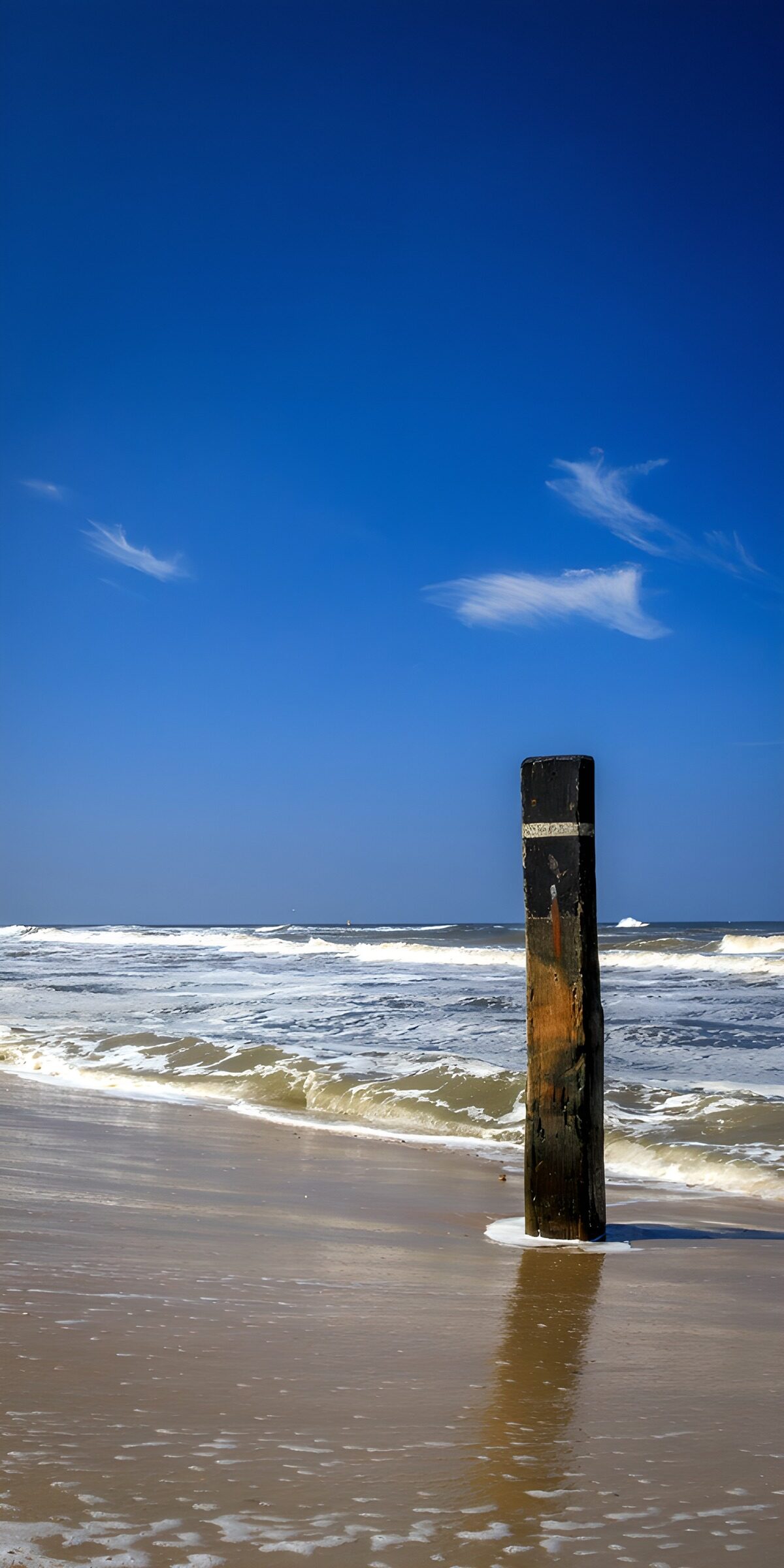 Weathered post on a sunlit shore