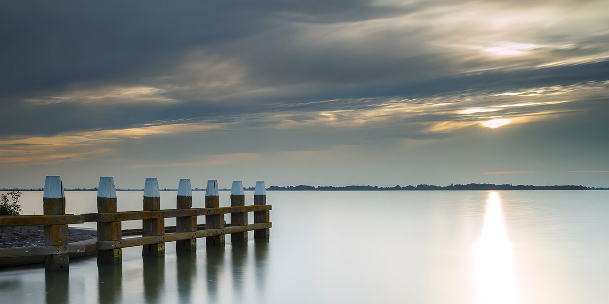 Wooden jetty beneath a clouded sky
