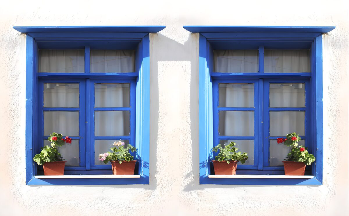 Sunlit blue windows with flowerpots