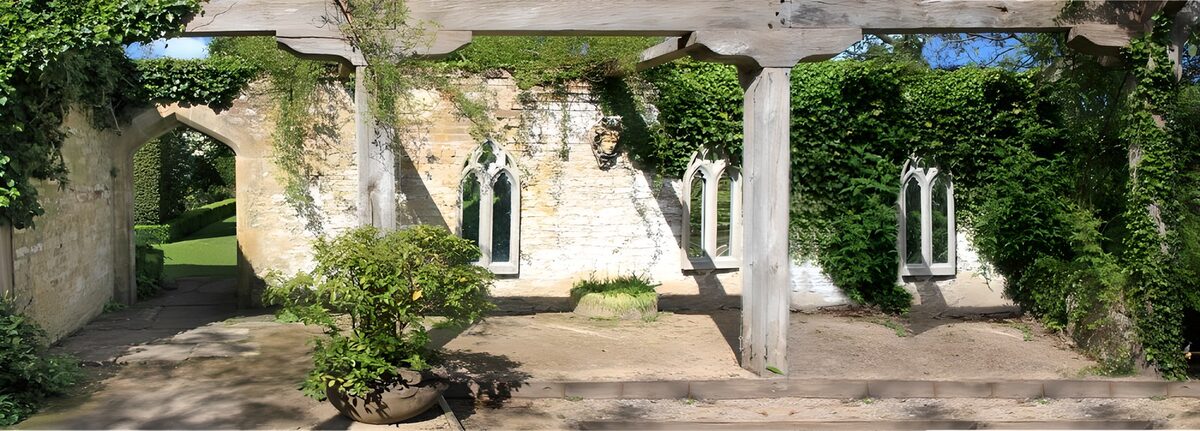 Sunlit garden beside a crumbling stone wall