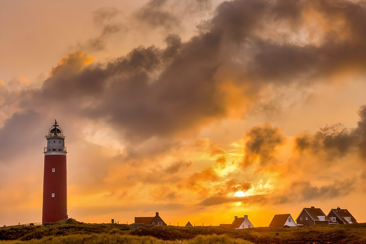 Red lighthouse beneath a sunset sky