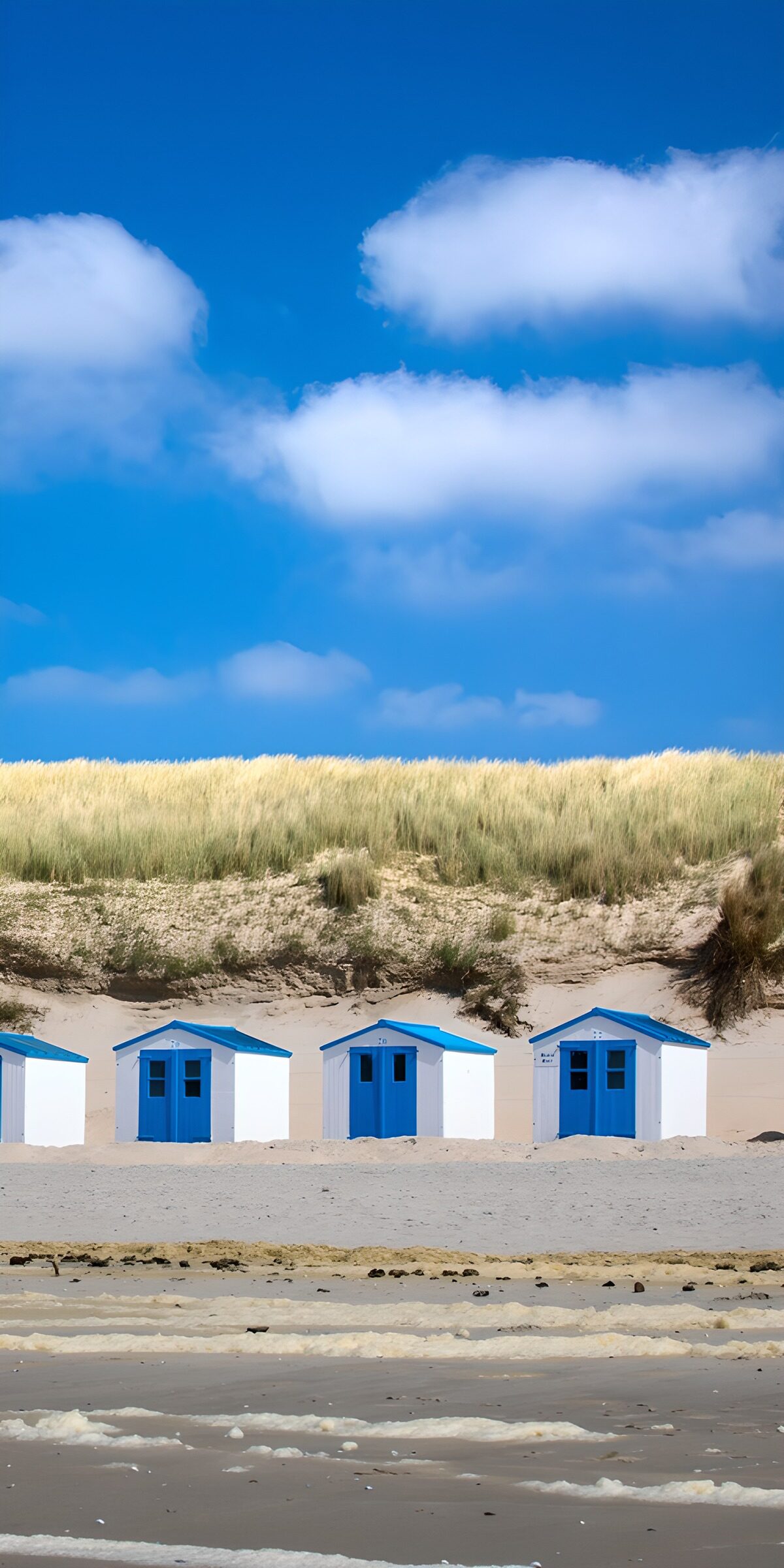 Beach huts beneath a cloud-soft sky