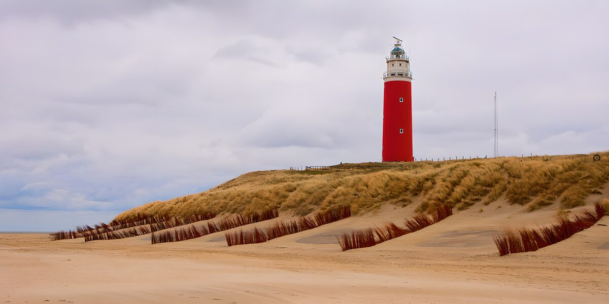 Red lighthouse above windswept dunes