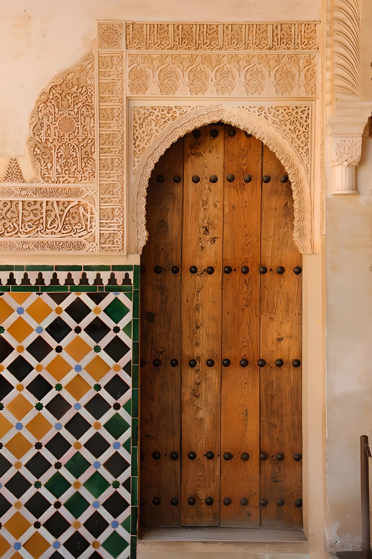 Weathered wooden door beneath an ornate arch