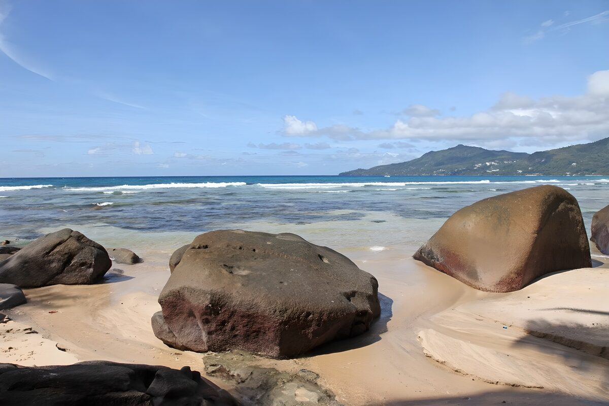 Sunlit boulders beside a blue-green sea