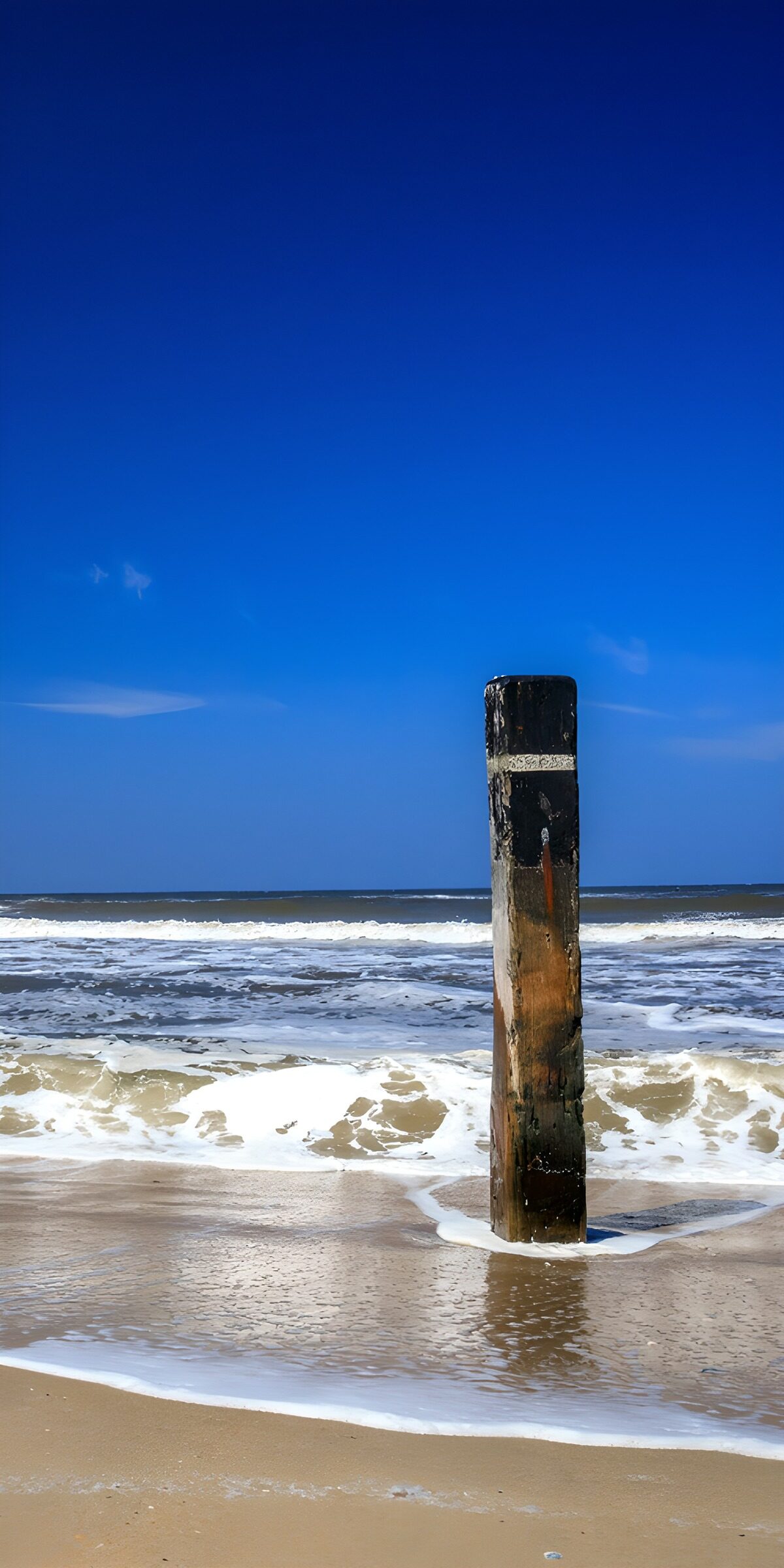 Weathered wooden post beneath a blue sky