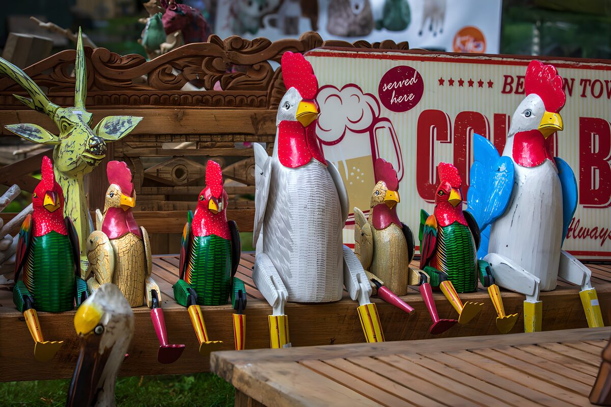 Colourful cockerel figures share a bench