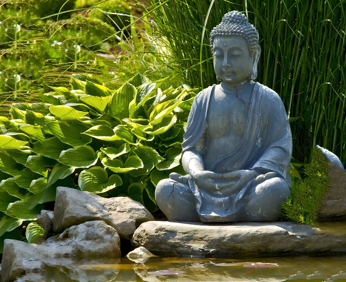 Buddha beside a quiet garden pond