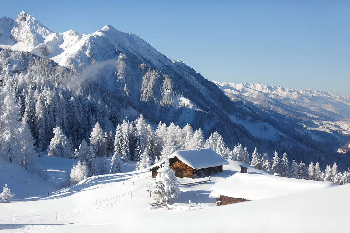Sunlit mountain huts in deep snow