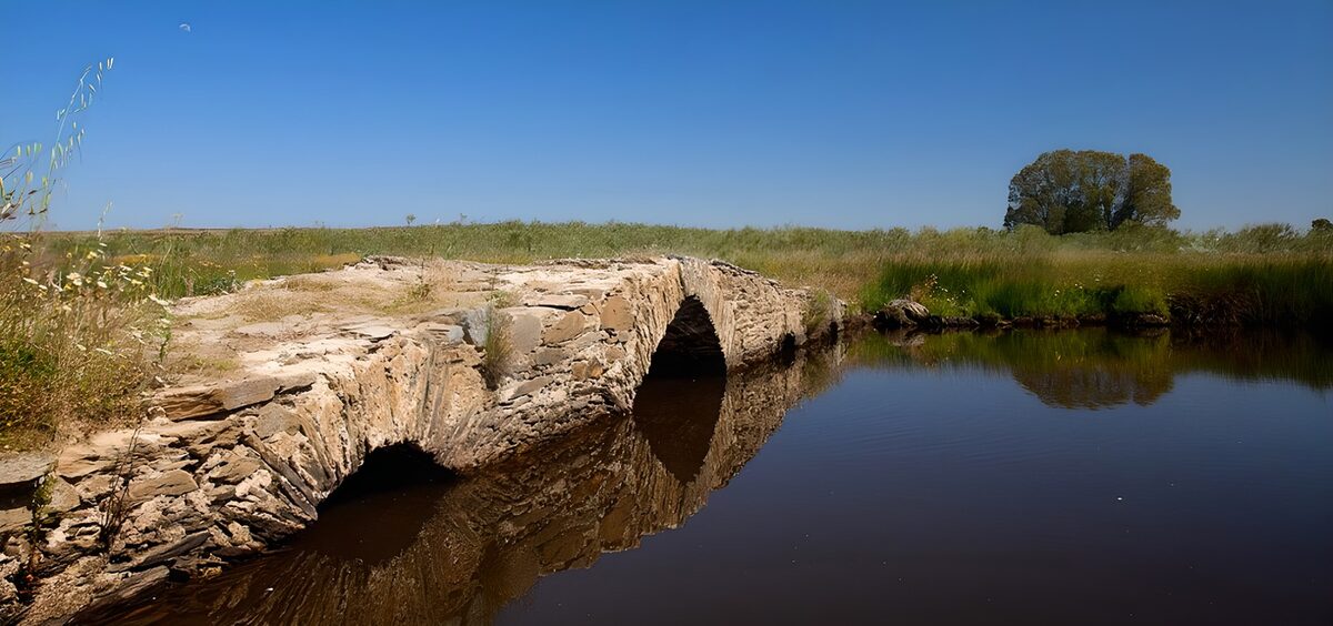 Old stone bridge over quiet water