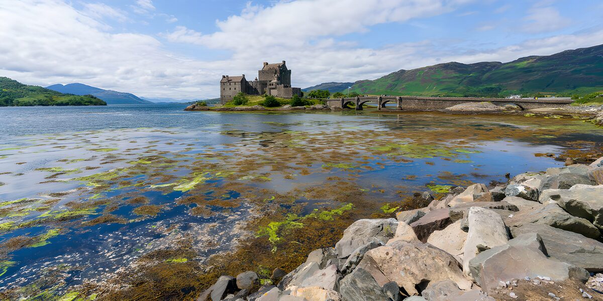 Scottish castle and bridge by calm water