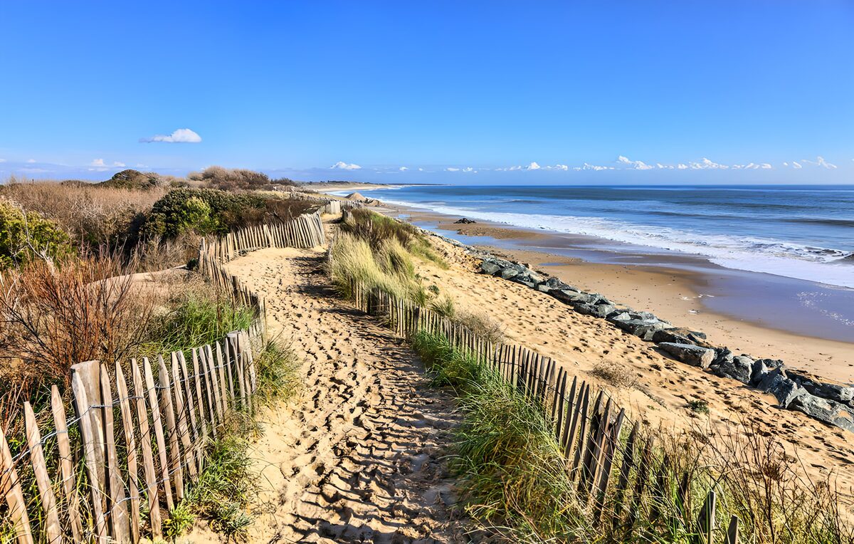 Sandy dune path beneath a blue sky