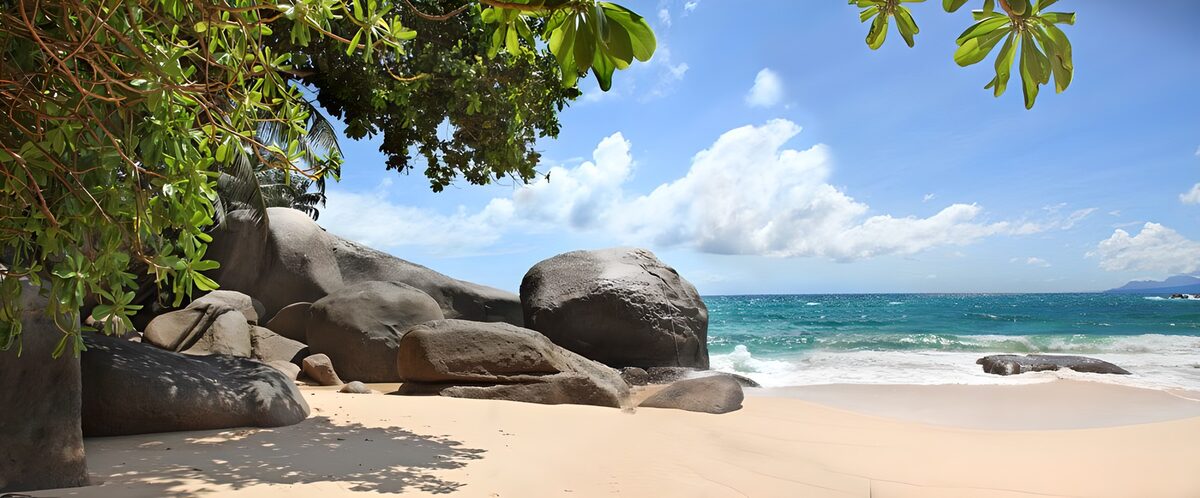 Tropical beach with sunlit boulders