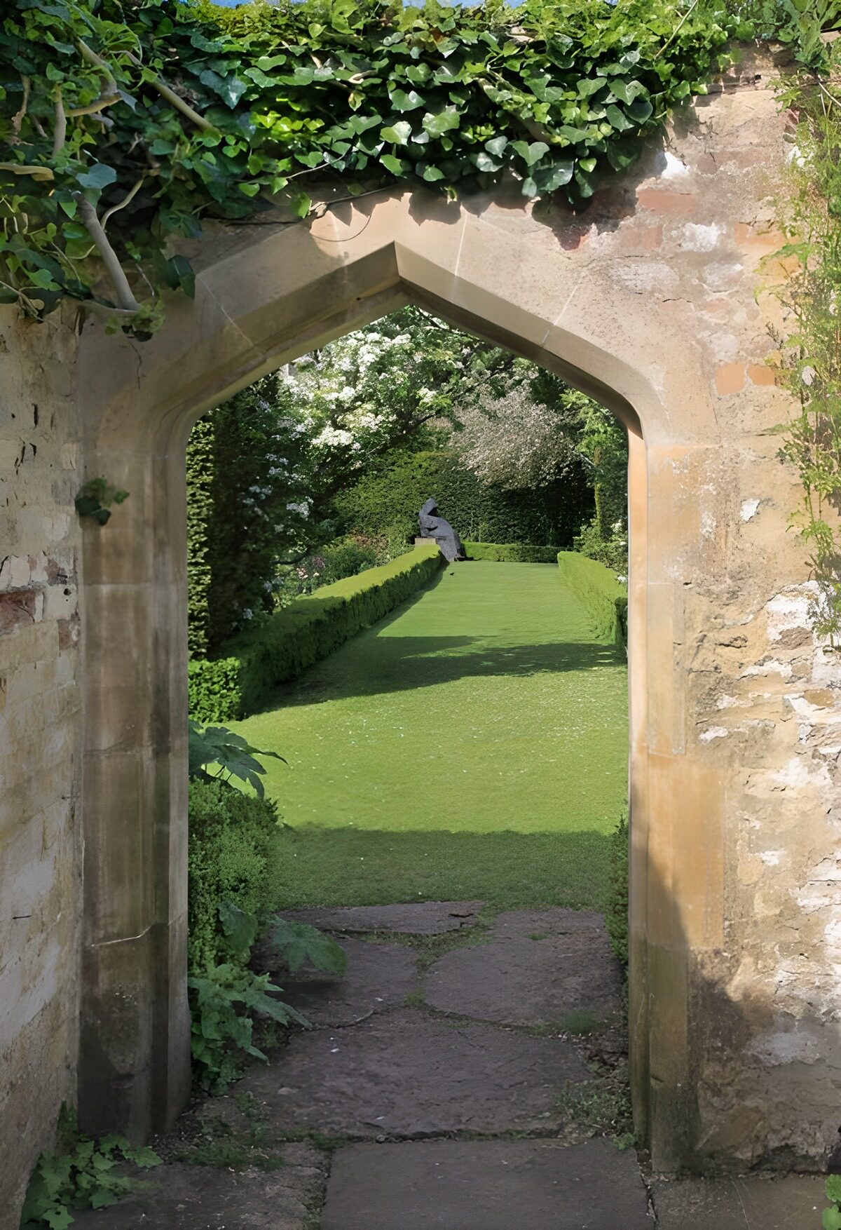Pointed stone arch into a sunlit garden