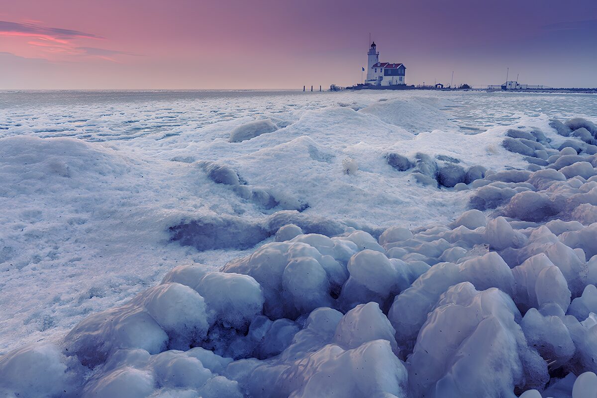 Lighthouse over ice in winter twilight