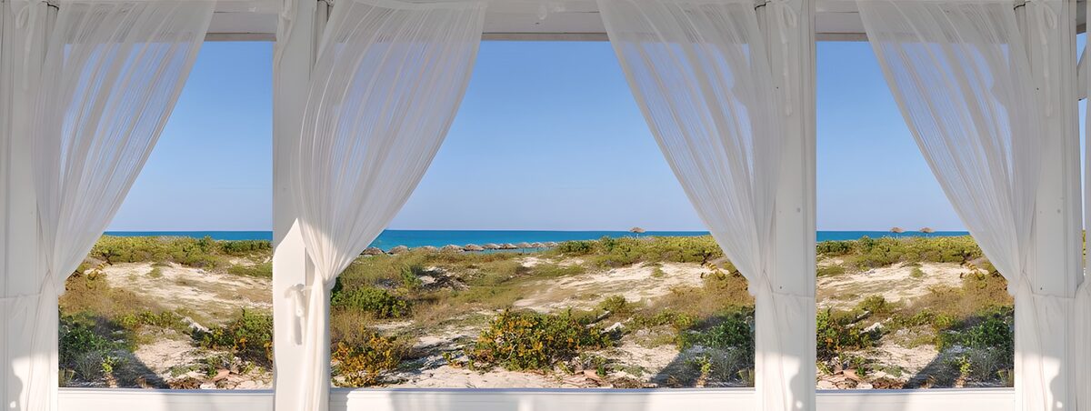 White curtains overlooking the sunlit sea