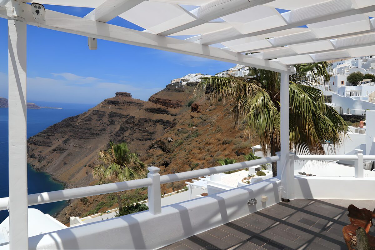 Sunlit terrace with palms and a sea view