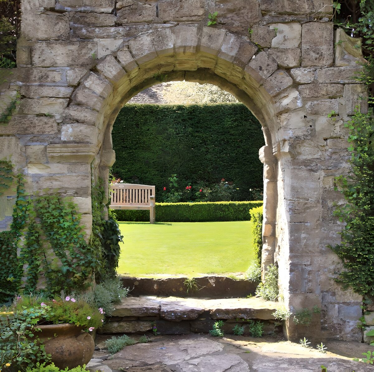 Stone archway into a sunlit garden