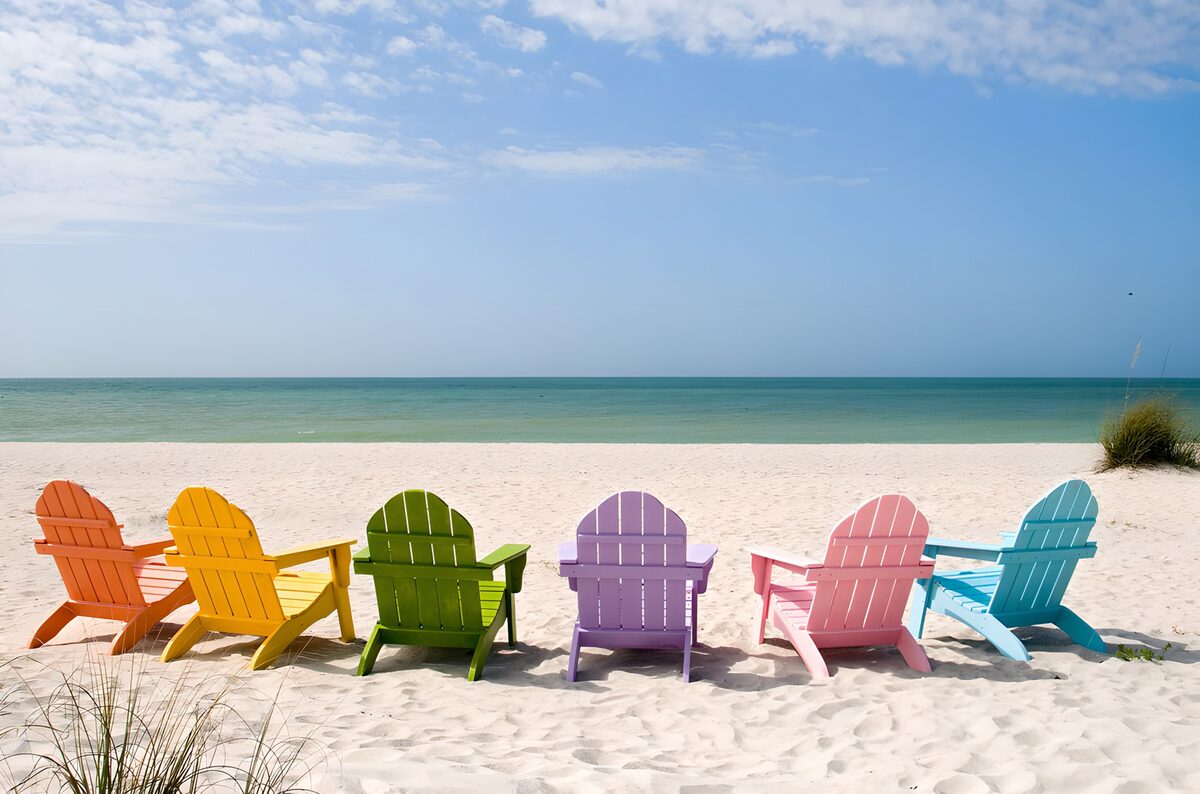 Six colourful beach chairs in the sun