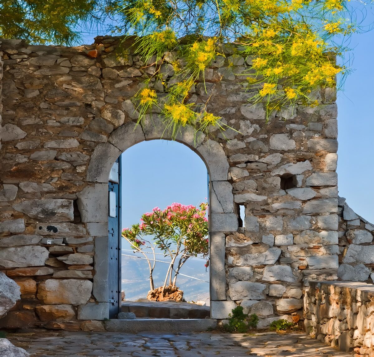 Sunlit stone arch with an open blue door
