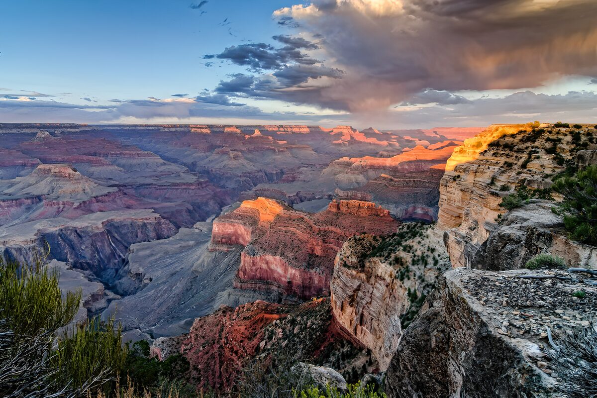 Golden canyon ridges beneath dark clouds