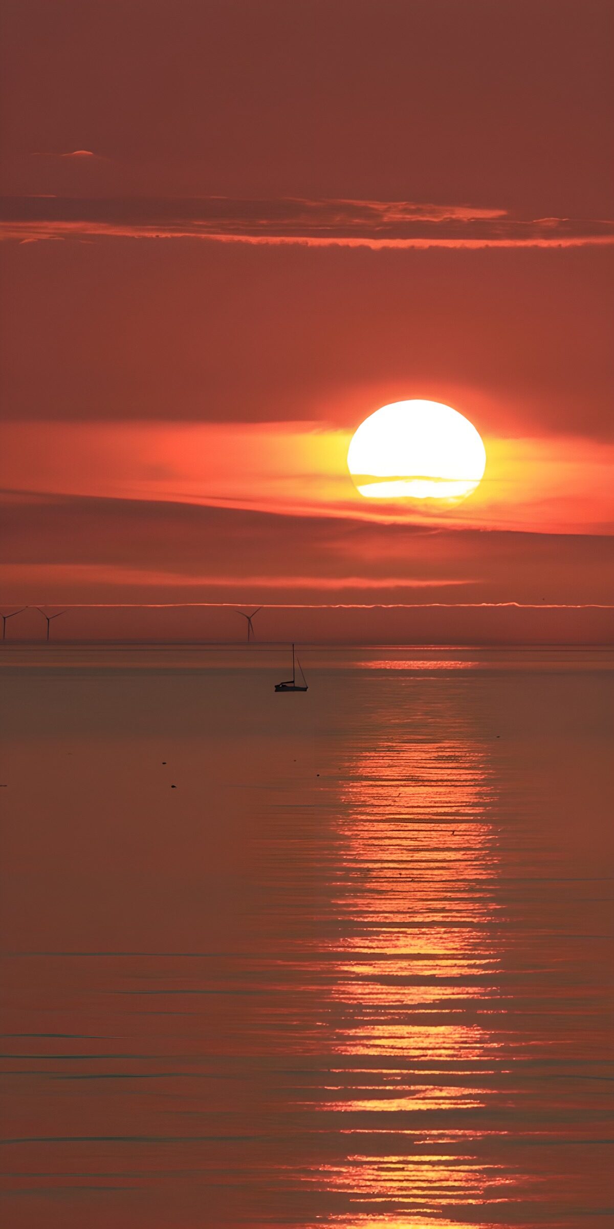 Sailboat beneath a blazing sunset