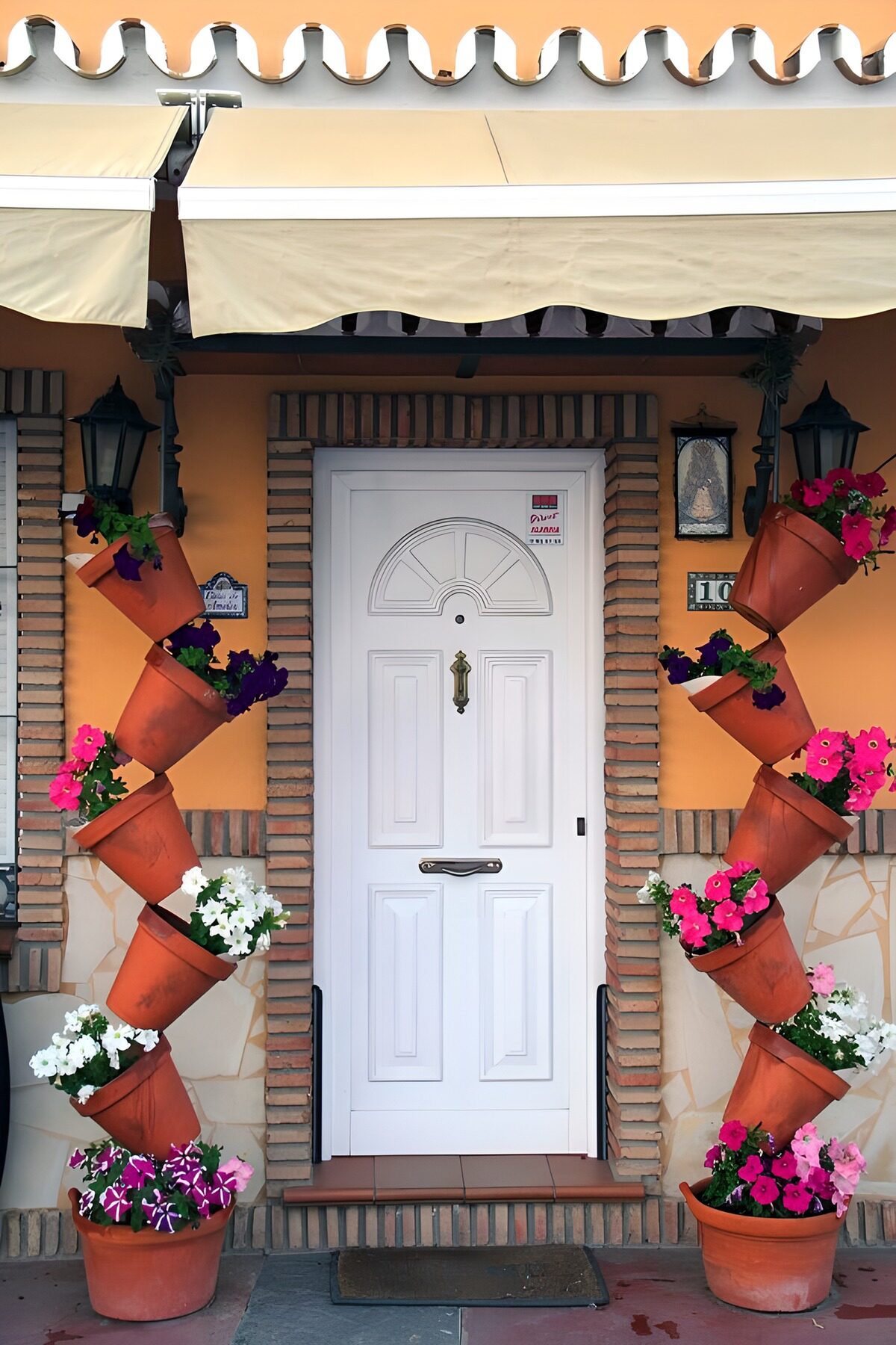 White front door framed by summer flowers
