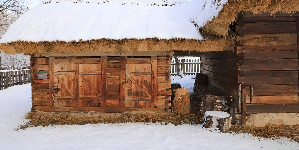 Snow-covered thatched outbuildings