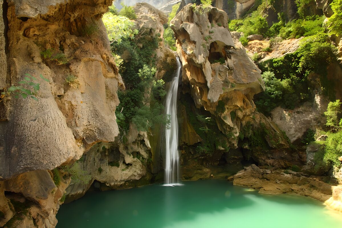 Waterfall and turquoise pool among rocks
