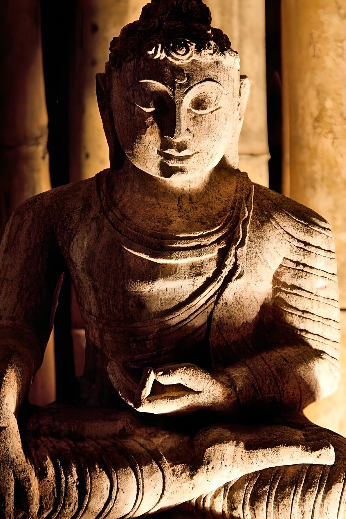 Weathered stone Buddha in golden light