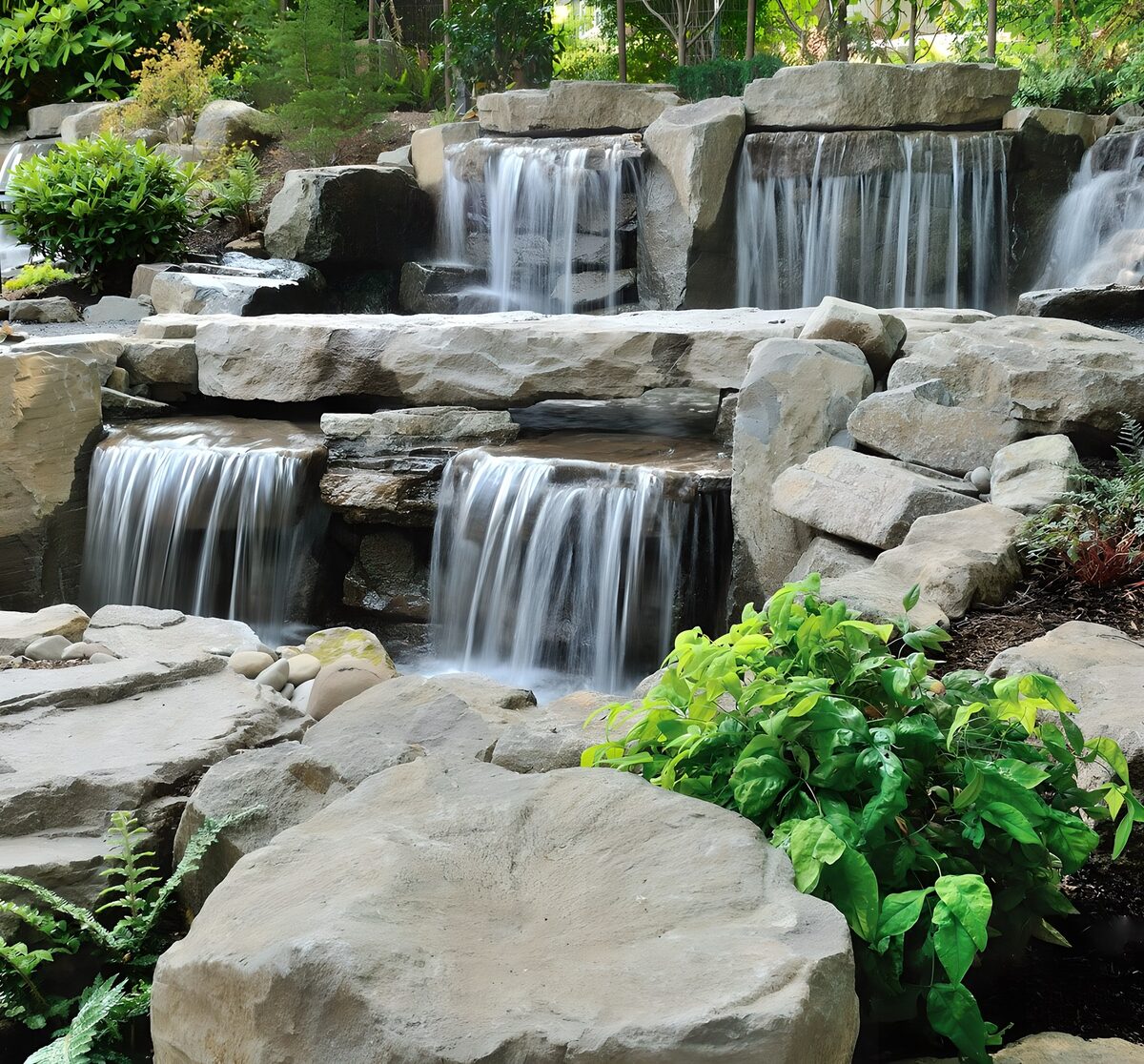 Tiered garden waterfall in dappled light