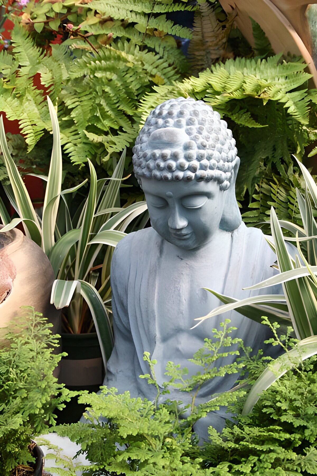Grey Buddha nestled among ferns