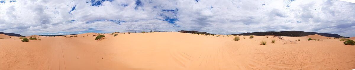 Warm orange dunes beneath a cloudy sky