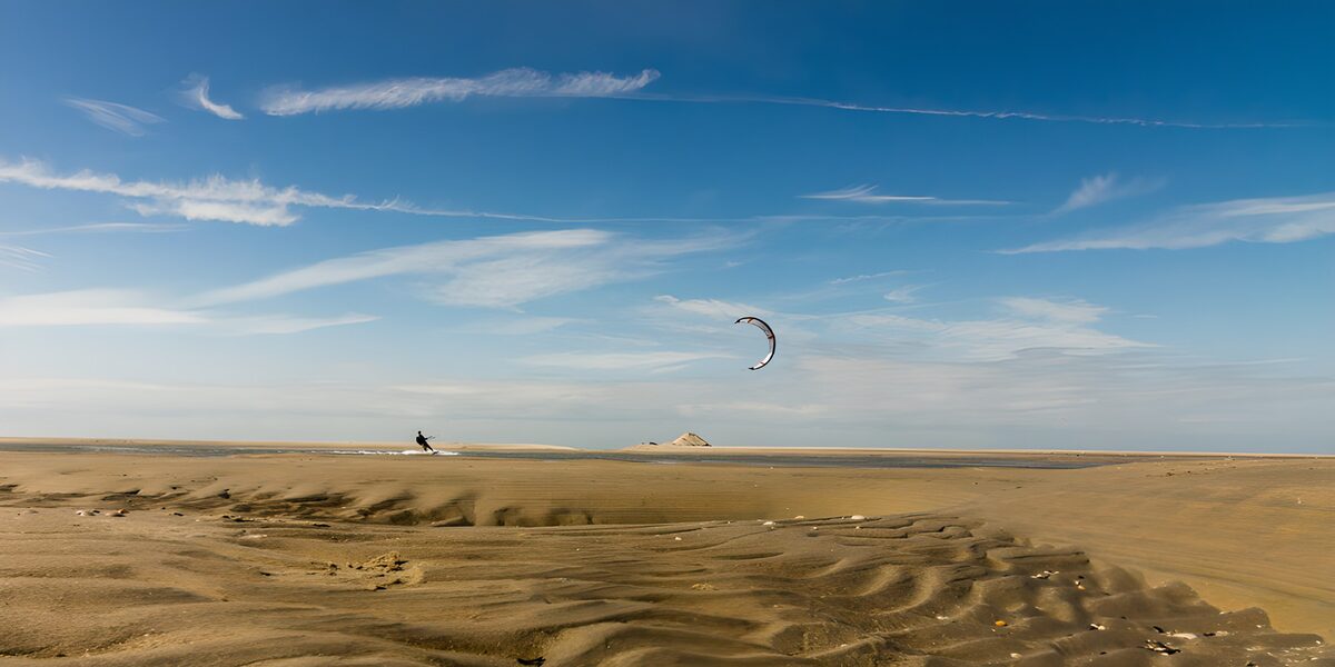 Kitesurfer beneath a wide blue sky