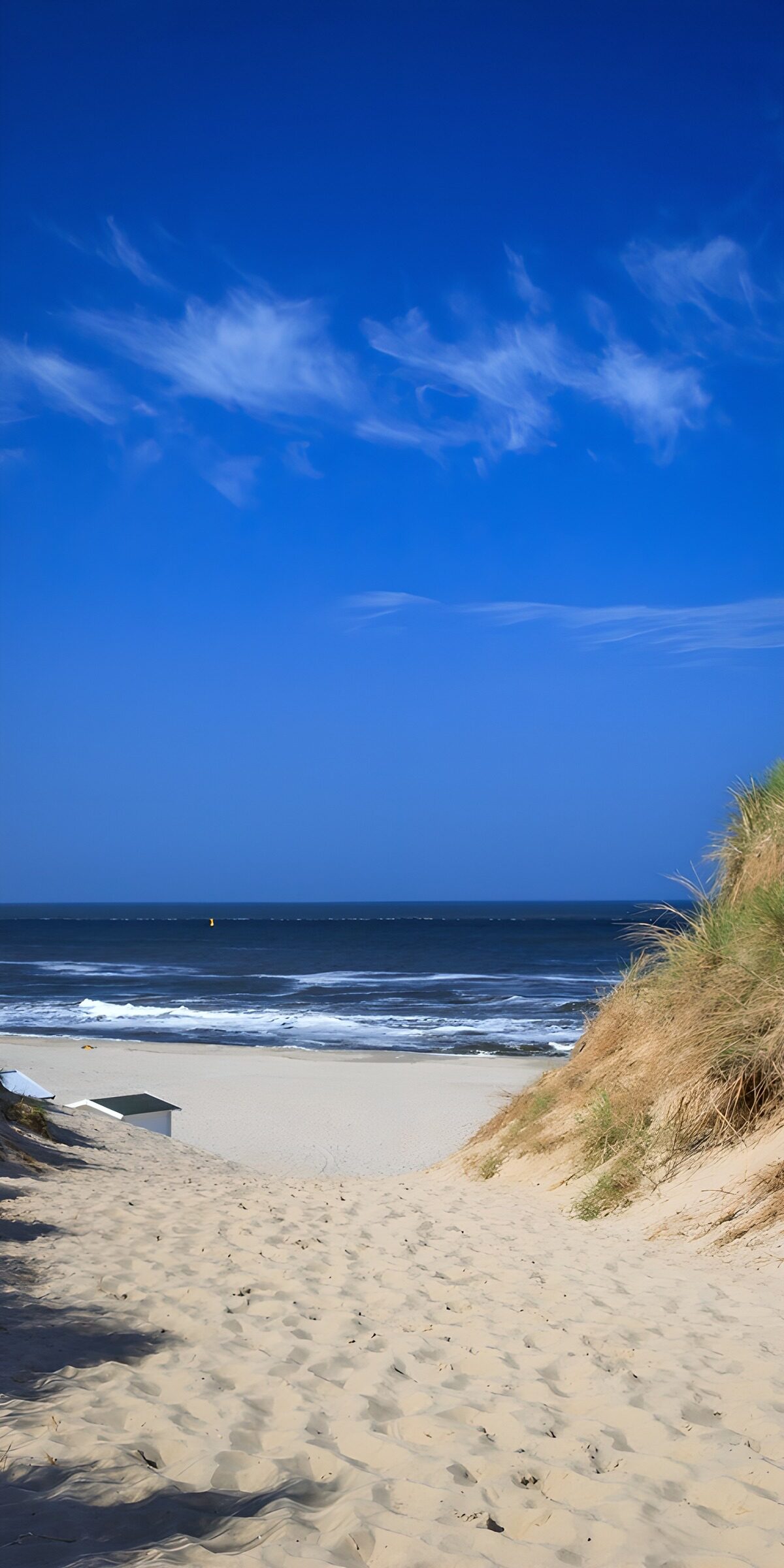 A ribbon of sand beneath a vast blue sky