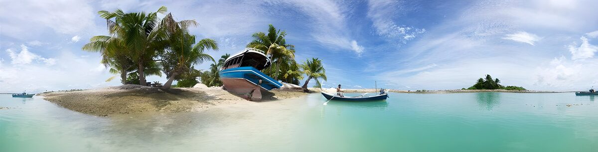 Palms and boats on a sunlit island beach