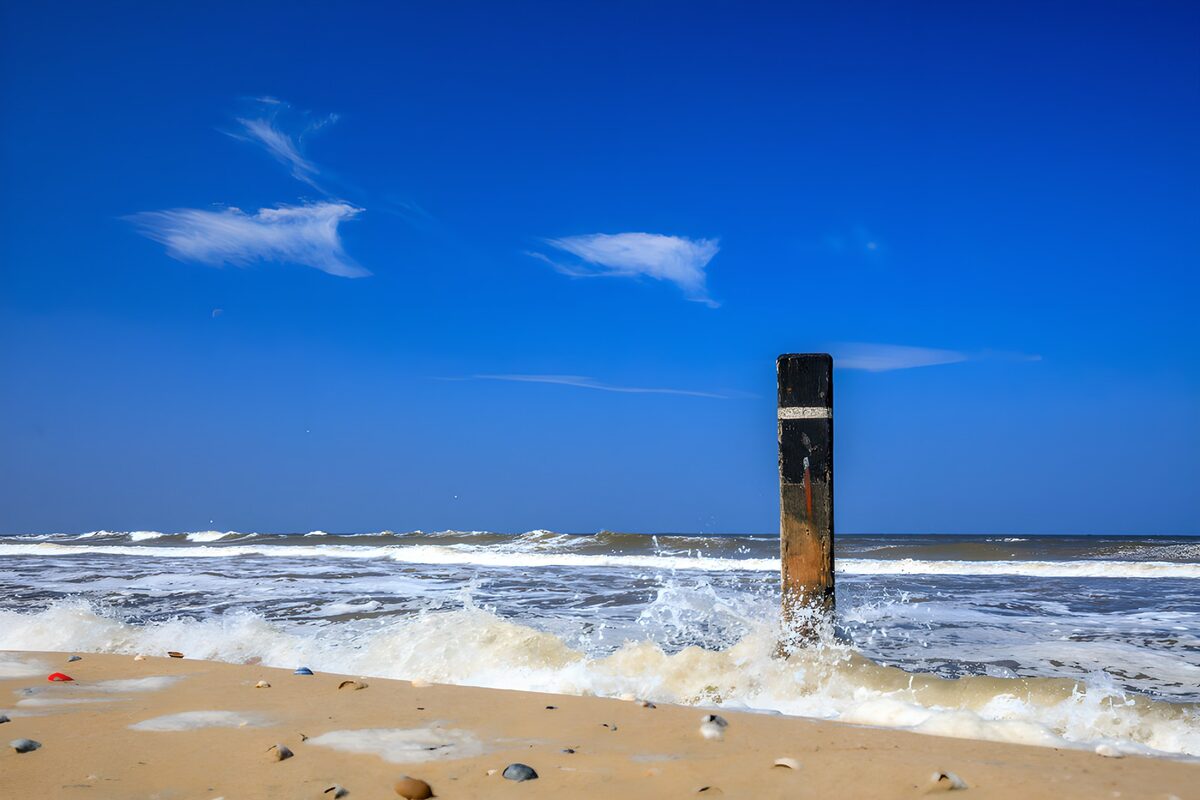 Lone beach post beneath a blue sky