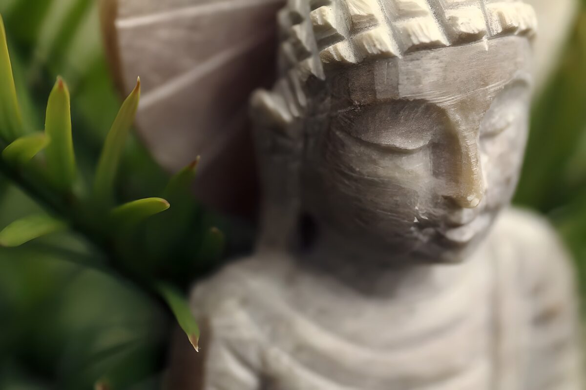 Grey Buddha framed by green leaves