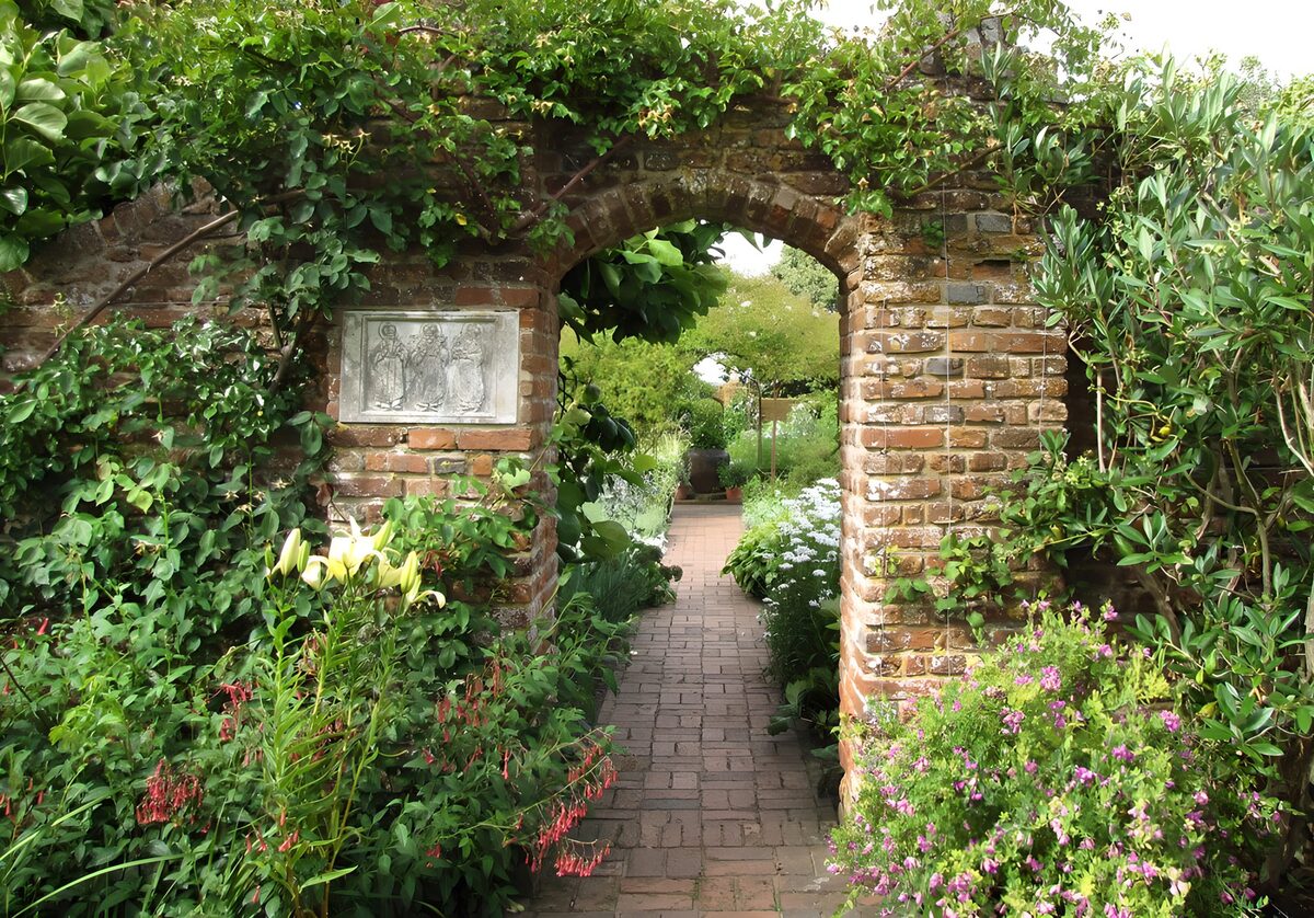 Weathered brick arch into a lush garden