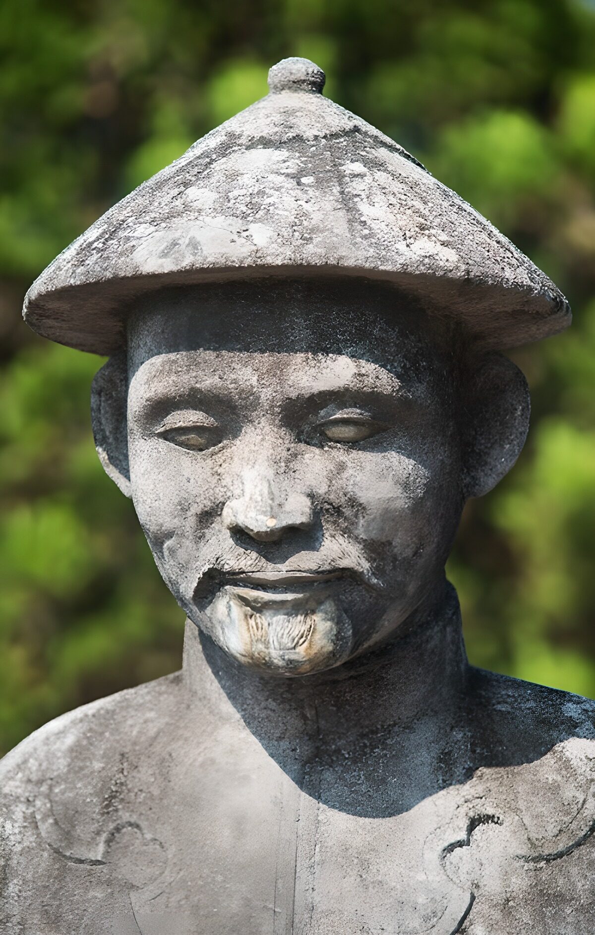 Weathered stone man in a conical hat