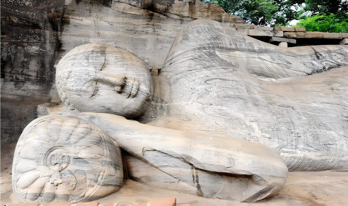 Reclining Buddha in pale, weathered stone