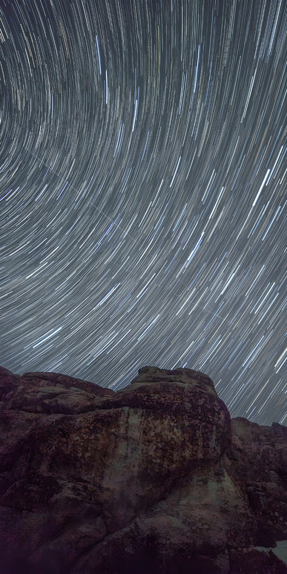 Star trails above a rugged rock ridge