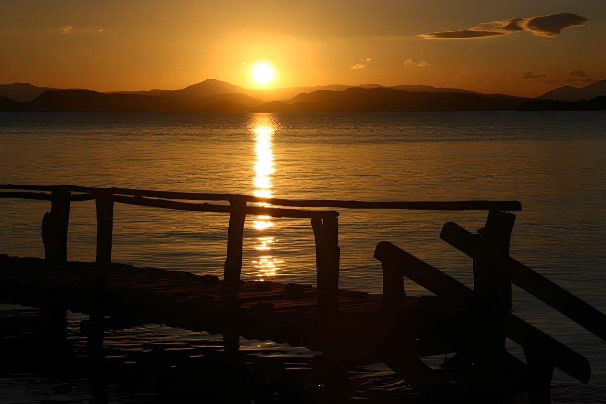 Wooden jetty and mountains at sunset