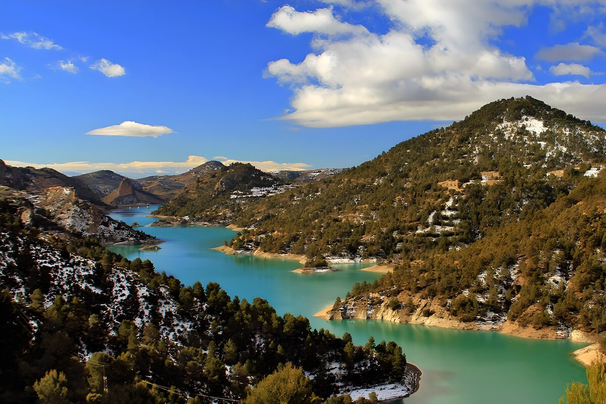 Turquoise lake beneath snow-dusted hills