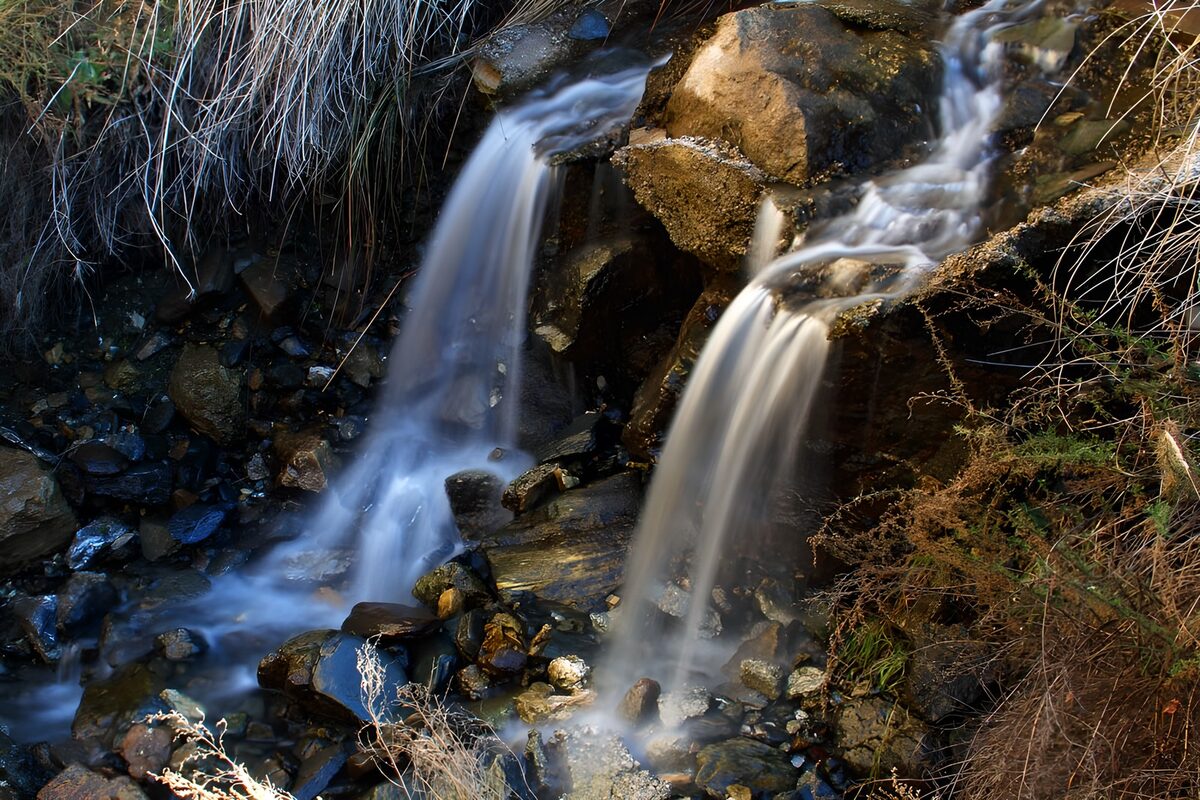 Twin waterfalls over dark rocks