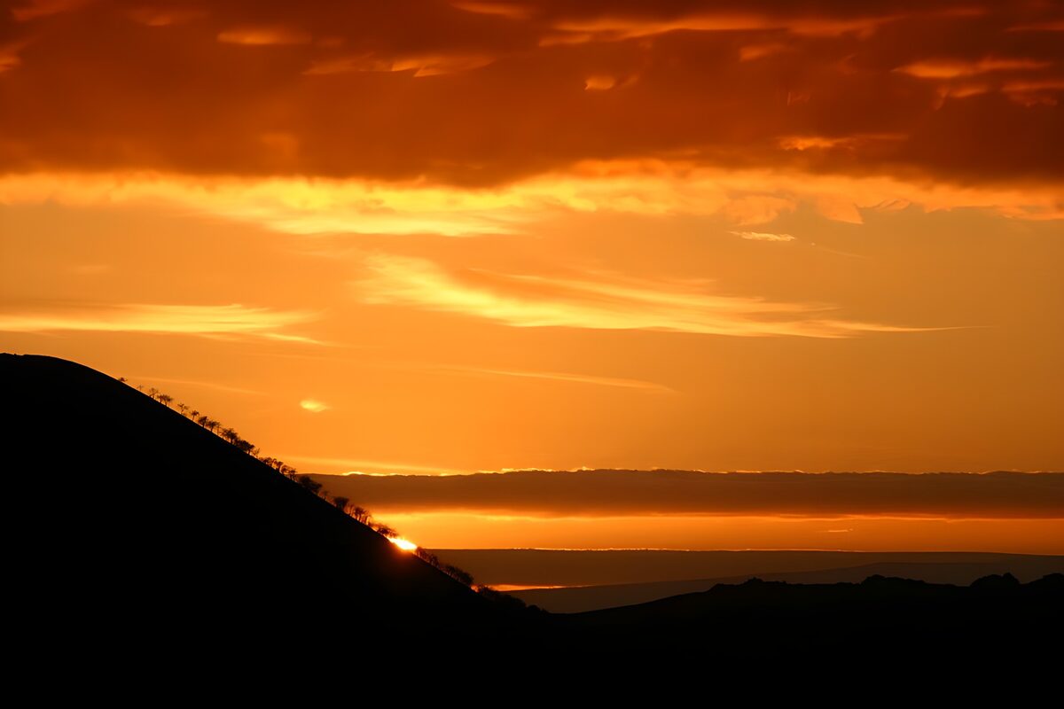 Golden sunset behind a silhouetted hill