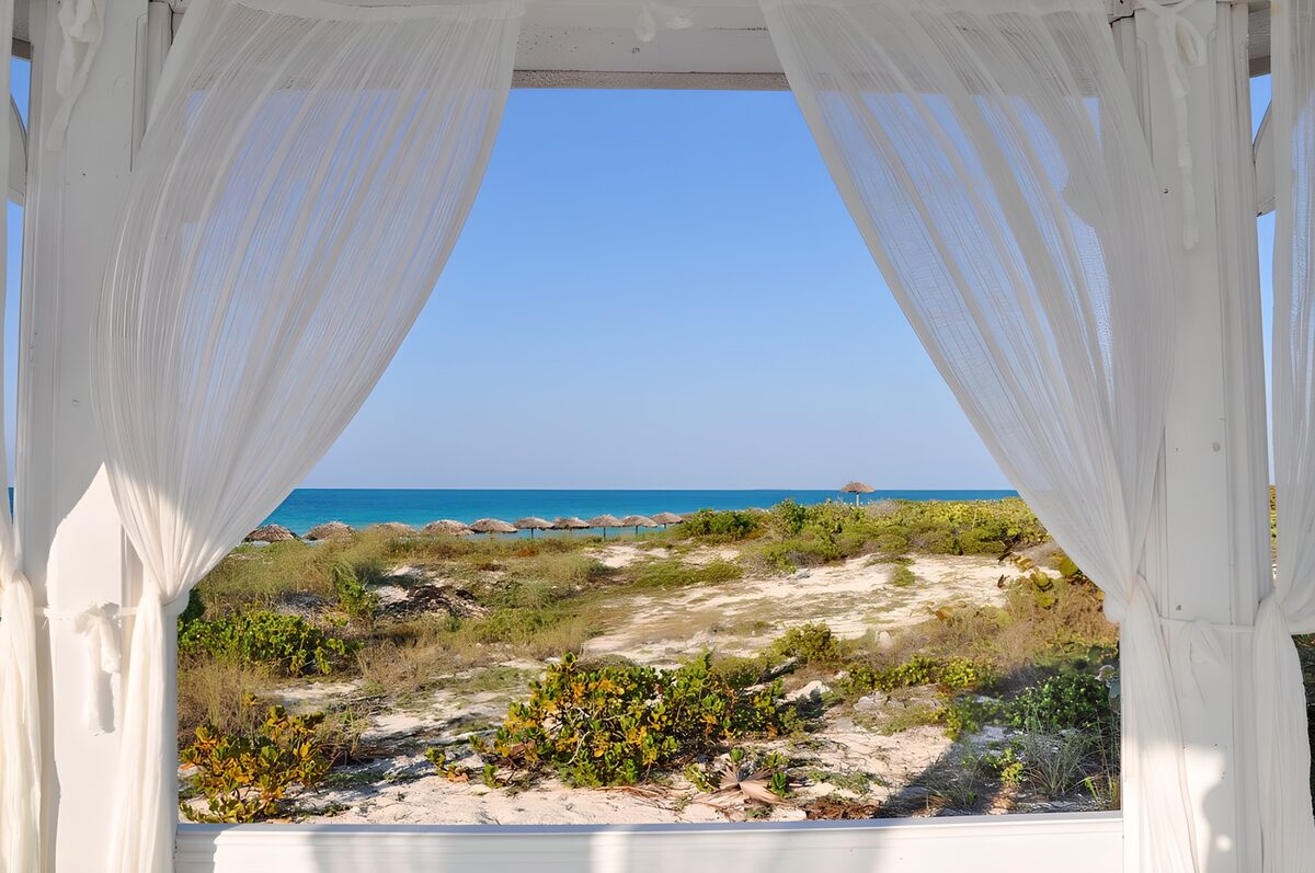 Sea view through white curtains
