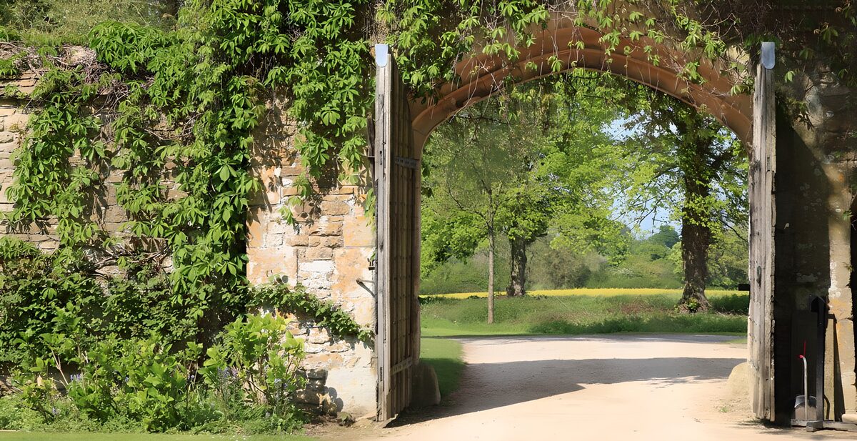 Open wooden gates to a sunlit garden