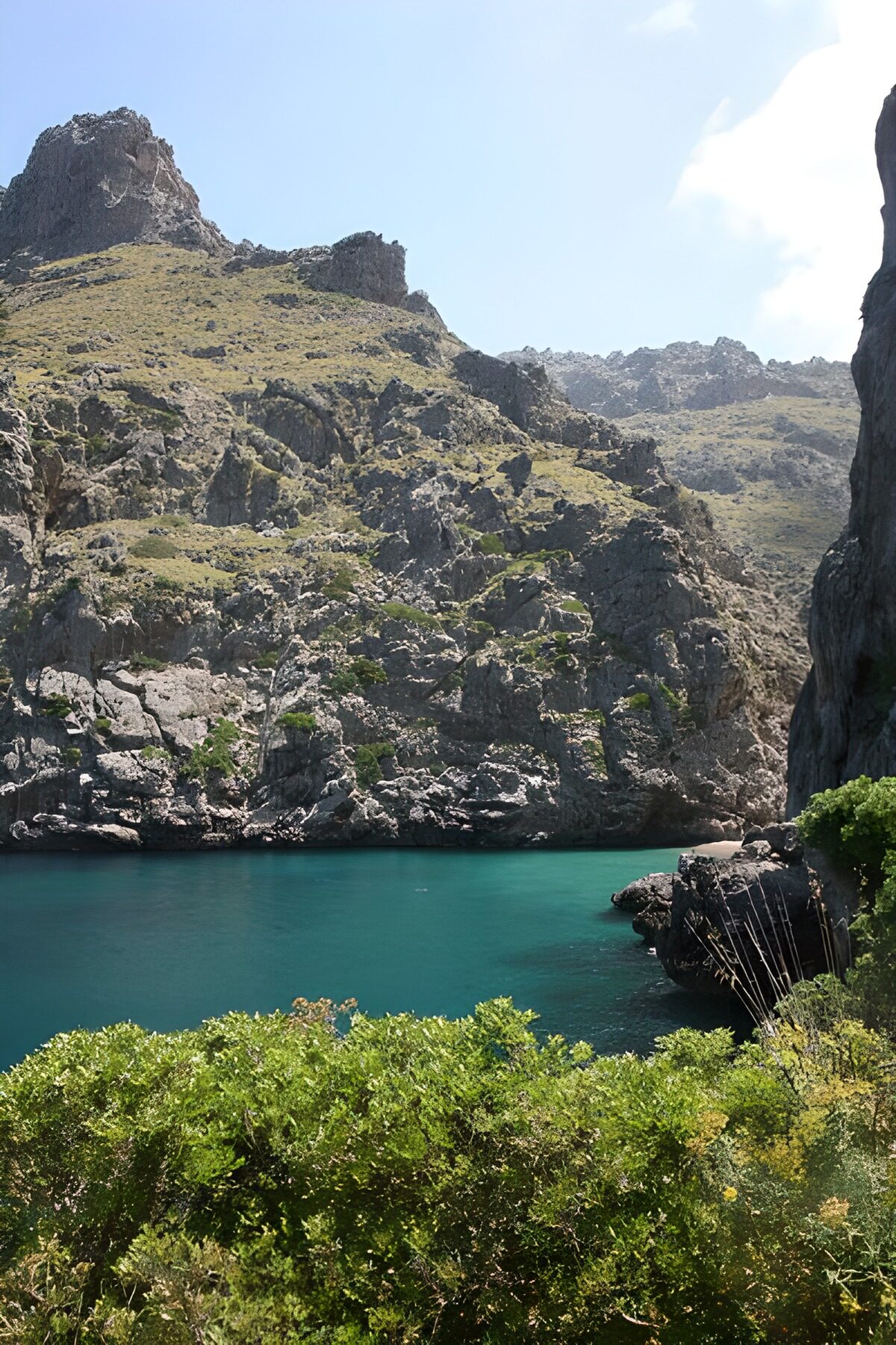 Calm turquoise cove beneath rugged cliffs