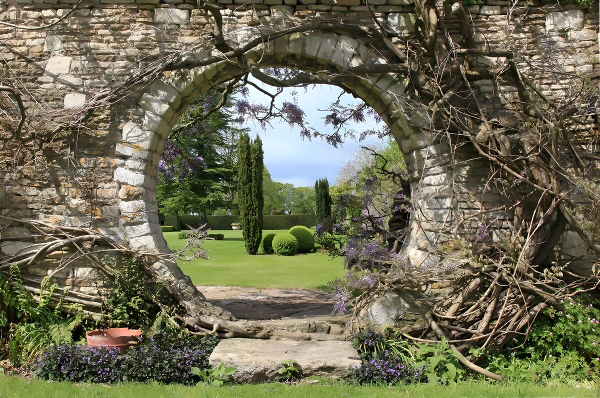 Round stone gateway to a sunlit garden
